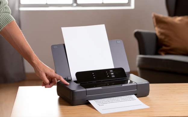 Pessoa utilizando impressora em ambiente corporativo, ilustrando aluguel de equipamentos de impressão.